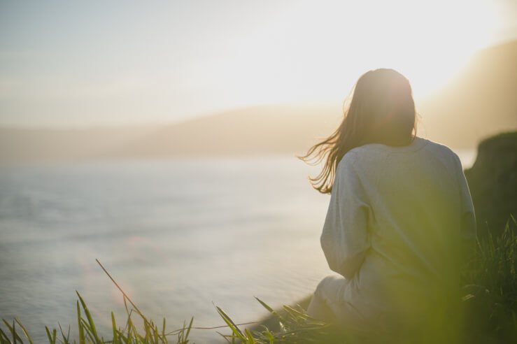 Woman sitting next to sea