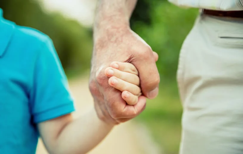 Grandfather holding the hand of his grandson